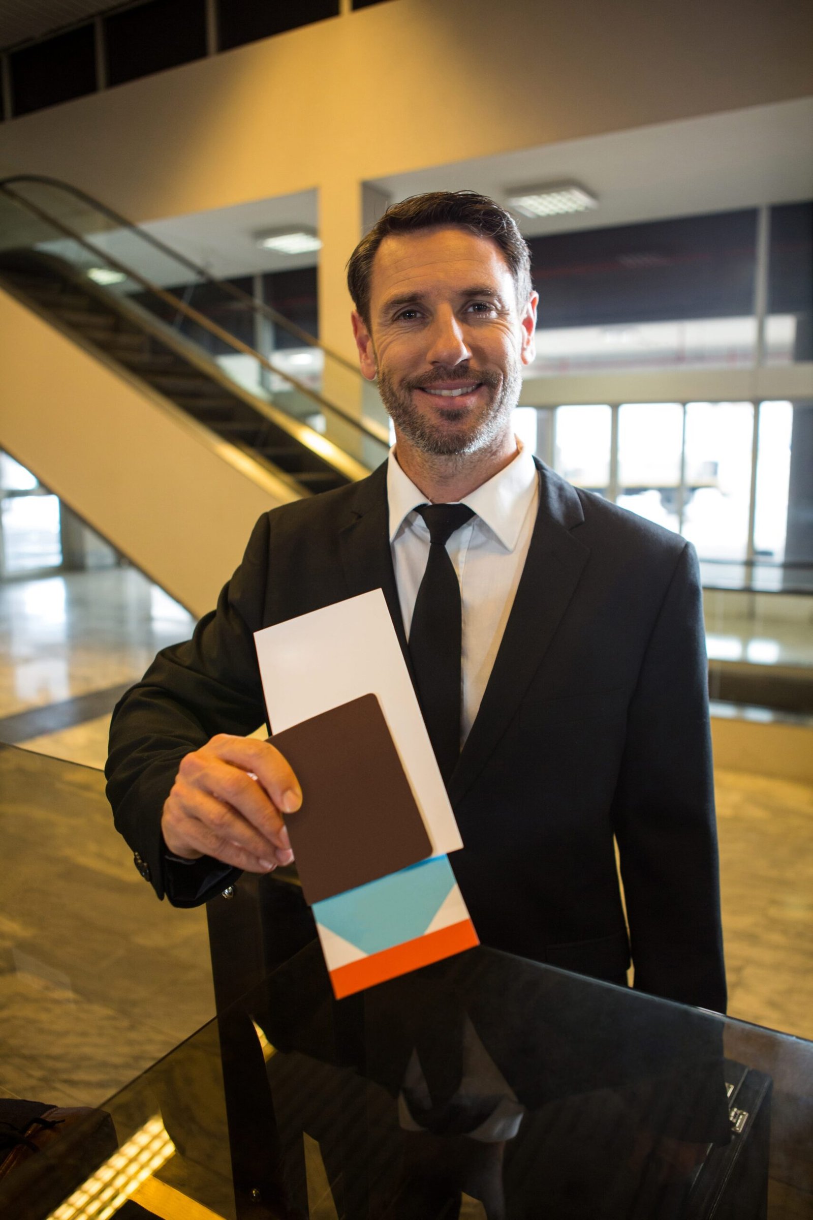 smiling-businessman-showing-his-boarding-pass-min